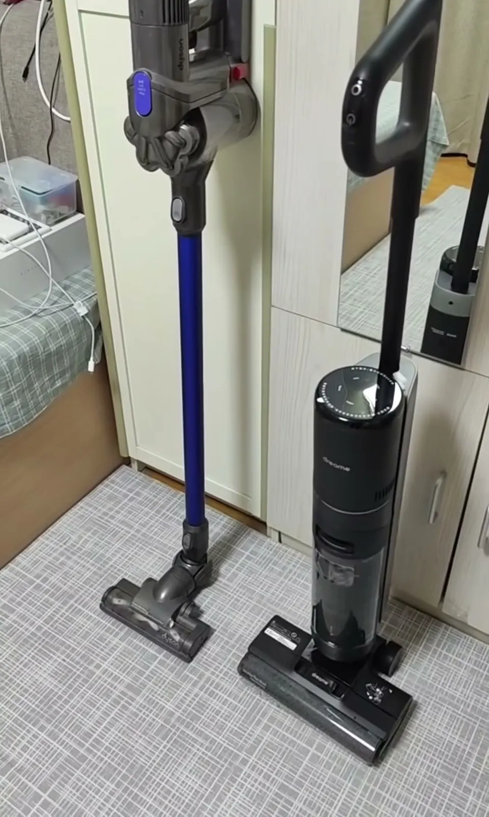 The dark upright on the right is the H12 Pro, parked next to the owner's stick vacuum.