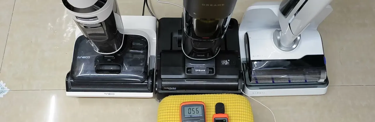 Metered after the heated dry cycle: a gray Tineco dock on the left, the black Dreame dock in the middle, a white dock on the right.
