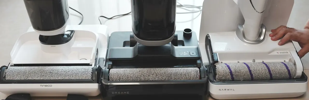 Roller brushes exposed side by side: a white Tineco on the left, the dark Dreame H14 Pro in the middle, a white Narwal on the right.