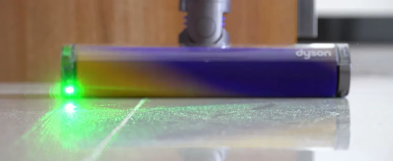 Dust that room lighting hides shows up as a bright scatter inside the green fan.