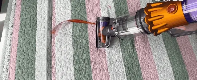Hair feeds straight in instead of winding around a brush: the red ribbon is the stand-in.