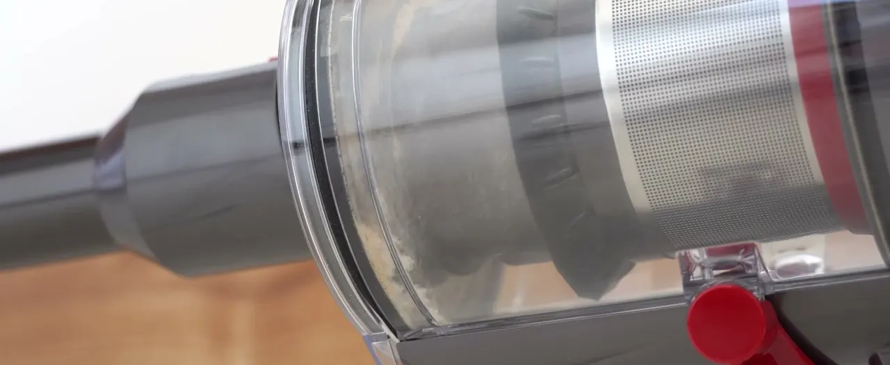 One lever push never finishes the job: the grey film coating the mesh shroud is the fine debris left behind.