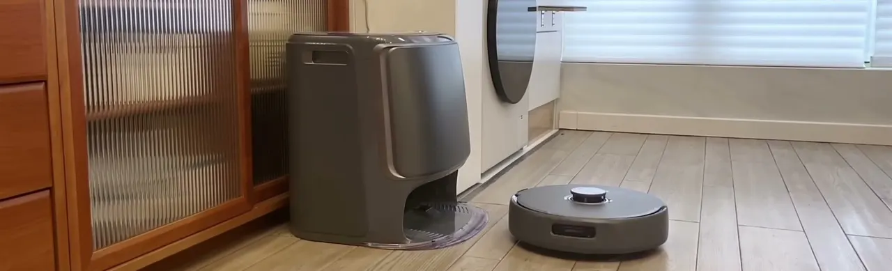 The dock handles washing, drying, and emptying; here it shares a corner of the room with the robot.